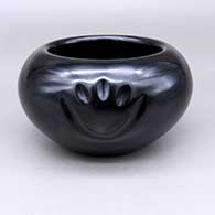 Black bowl with an indented bear paw design
 by Nathan Youngblood of Santa Clara