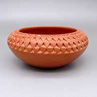 Red bowl with a corrugated texture design
 by Lucy Nahee of Hopi