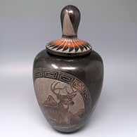 Lidded black jar with sienna spots and a sgraffito deer, eagle, mountain and geometric design
 by Corn Moquino of Santa Clara