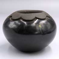 Polished black jar with a carved and painted matte black cloud design around the neck
 by Glenda Naranjo of Santa Clara