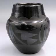 Black-on-black jar with a raised rim and a cloud formation and 4-panel geometric design
 by Frances Salazar of Santa Clara