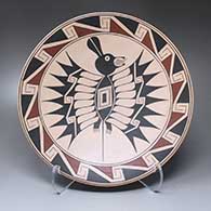 A polychrome plate with a Mimbres bat and geometric design on its face
 by Sabino Villalba of Mata Ortiz and Casas Grandes