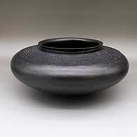 Large micaceous black bowl with a flared opening and a corrugated design
 by Preston Duwyenie of Hopi