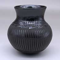A black-on-black jar decorated with a geometric design around the body and a band of corrugation at the bottom of the neck
 by Tomasa Mora of Mata Ortiz and Casas Grandes