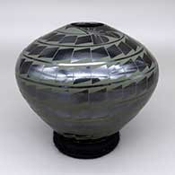 Black and green jar with a spiral geometric design
 by Juana Dominguez of Mata Ortiz and Casas Grandes