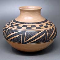 A black-on-yellow jar with an everted rim and a checkerboard and geometric design around and above the shoulder
 by Fawn Navasie of Hopi