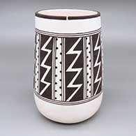 Black and white jar with a tapered, cylindrical shape and a geometric design
 by Myron Sarracino of Laguna