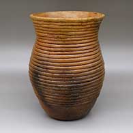 Brown jar with a pine pitch coating, a flared opening, fire clouds and an exposed coil design
 by Louise Goodman of Dineh