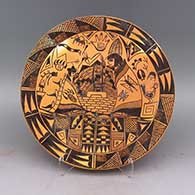 Black and brown plate with people, kokopelli, bear paw, snake, handprint, bird, butterfly, geometric design and fire clouds
 by Billy Tawyesva of Hopi