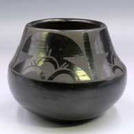 Black-on-black jar with a 4-panel geometric design above the shoulder
 by Cresencia Tafoya of Santa Clara