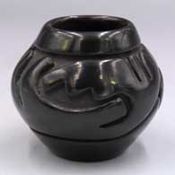 Small black jar carved with a stylized avanyu design
 by Sunday Chavarria of Santa Clara