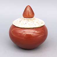 Polished red lidded jar with micaceous slip on inside, includes matching metal lid with polished clay, micaceous slip, and heishi bead strand details
 by Jennifer Tse Pe of San Ildefonso