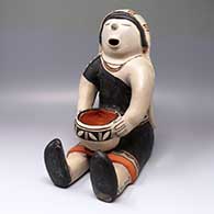 Polychrome seated figure holding jar
 by Helen Cordero of Cochiti
