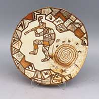 Polychrome plate decorated with a kokopelli, spiral, bear paw, lizard, cornstalk, spider, shard pattern and geometric design
 by Lawrence Namoki of Hopi