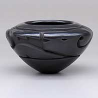 A small black bowl carved with an avanyu design around the shoulder
 by Effie Garcia of Santa Clara