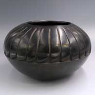 Black jar carved with a ring of feathers design
 by Camilio Tafoya of Santa Clara
