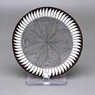 Small black-on-white plate with a fine line and feather ring geometric design
 by Rebecca Lucario of Acoma