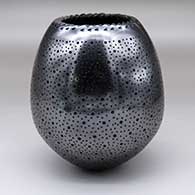 A black jar with a notched rim and geometric drill hole design
 by Mariano Quezada of Mata Ortiz and Casas Grandes