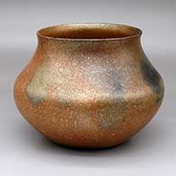 A golden micaceous jar with a flared rim and fire clouds
 by Lonnie Vigil of Nambe