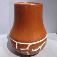 Red jar carved with a stylized avanyu and geometric design
 by Luann Tafoya of Santa Clara