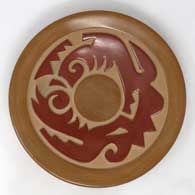 Red and brown plate carved with stylized avanyu and geometric design
 by Nathan Youngblood of Santa Clara
