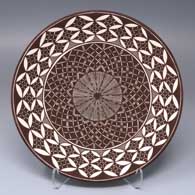 Black-on-white plate with a fine line, pumpkin seed snowflake and geometric design
 by Amanda Lucario of Acoma