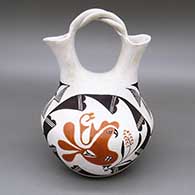 Polychrome wedding vase with a braided handle and a parrot, flower, fine line, and geometric design
 by Carrie Chino Charlie of Acoma