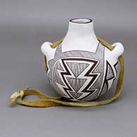 Black-on-white canteen with a fine line and geometric design and a leather strap detail
 by Delores Aragon Juanico of Acoma