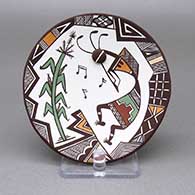 Small polychrome plate with an applique and painted kokopelli, cornstalk, music note, fine line, and geometric design on top and an applique and painted ladybug detail on bottom
 by Carolyn Concho of Acoma