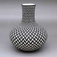 A tall-neck black-on-white vase with a square neck and decorated with a herringbone geometric design
 by Paula Estevan of Acoma