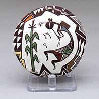 A small polychrome seed pot with a kokopelli, corn plant and geometric design above the shoulder and a lady bug applique below the shoulder
 by Carolyn Concho of Acoma