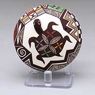 A small polychrome seed pot with a turtle and geometric design above the shoulder and a lady bug applique below the shoulder
 by Carolyn Concho of Acoma