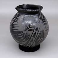 Black-on-black jar with a flared square opening, a carved texture detail around the rim, and a painted geometric design
 by Oscar Quezada of Mata Ortiz and Casas Grandes