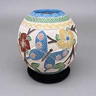 Polychrome jar with a lightly carved, sgraffito, and painted butterfly, flower, branch, berry, leaf, and geometric design
 by Melissa Tena of Mata Ortiz and Casas Grandes