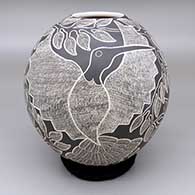Black and white jar with a sgraffito hummingbird, flower, branch, and leaf design
 by Lorenza Quezada of Mata Ortiz and Casas Grandes