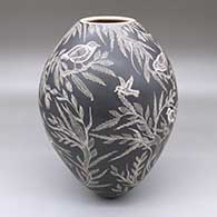 A black-on-white jar with a sgraffito bird, branch and leaf design
 by Arturo Quezada of Mata Ortiz and Casas Grandes