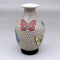A polychrome jar with a rolled lip and decorated with a butterfly and geometric mesh design
 by Olga Arras of Mata Ortiz and Casas Grandes