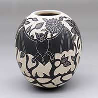 A black-on-white jar with a sgraffito bat, flower and vine design
 by Diana Loya of Mata Ortiz and Casas Grandes