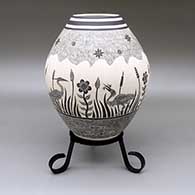 Black-on-white jar with a sgraffito riparian scene design featuring heron, fish, cattail, flower, and spiral geometric elements
 by Adrian Corona of Mata Ortiz and Casas Grandes