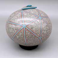 Polychrome lidded jar with a fine line and geometric design and a matching triangular lid with an inlaid turquoise stone detail
 by Oralia Lopez of Mata Ortiz and Casas Grandes