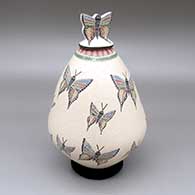 Polychrome lidded jar with a sgraffito and painted butterfly and geometric design and a matching lid with an applique butterfly detail
 by Oscar Ramirez of Mata Ortiz and Casas Grandes