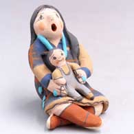 Miniature grandmother storyteller with 1 child on her lap
 by Mary Lucero of Jemez