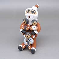Polychrome Santa Claus storyteller with three children, a ball, and wrapped presents
 by Felicia Fragua of Jemez