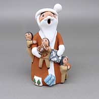Polychrome Santa Claus storyteller with three children, a football, a basketball, and wrapped presents
 by Diane Lucero of Jemez