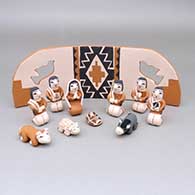 Small eleven-piece polychrome nativity set with a backdrop featuring dove cut-out details
 by Angel Bailon of Jemez