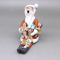 Polychrome Santa Claus storyteller with four children, presents, a basketball, a tennis racquet and ball, and a candy cane
 by Diane Lucero of Jemez
