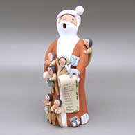 Large polychrome Santa Claus storyteller with six children, a puppy, a basketball, a baseball and bat, wrapped presents, and a list
 by Diane Lucero of Jemez