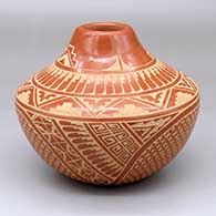 A red jar with a sgraffito feather, kiva step, snowflake and geometric design
 by Wilma Baca Tosa of Jemez