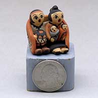 Click for a larger view A miniature grandmother and grandfather storyteller figure wearing a manta with two children and a drum
by Chrislyn Fragua of Jemez