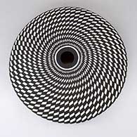 A black-on-white seed pot decorated with a spiral checkerboard geometric design
 by Robert Kasero Sr of Laguna